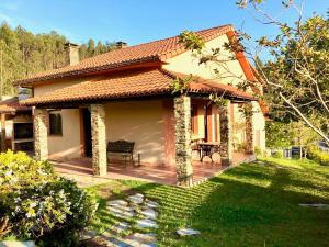 a house with a wooden deck in a yard at The Cliffs - Morandaina Beach in O Vicedo