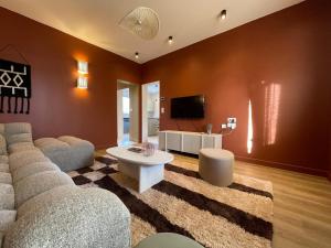 a living room with a couch and a tv at Maison rénovée Lacanau Ocean in Lacanau