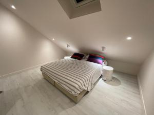 a bedroom with a bed with striped sheets and pillows at Maison rénovée Lacanau Ocean in Lacanau