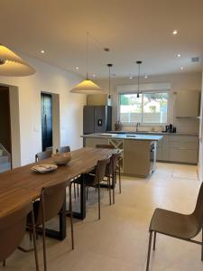 a kitchen and dining room with a wooden table and chairs at Maison rénovée Lacanau Ocean in Lacanau