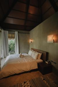a bedroom with a large bed and a window at Mémé Villa Siargao in General Luna