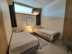 a small room with two beds and a window at Marina Resort A8 in Kalajoki