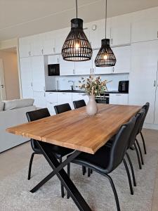 a dining room table with black chairs and two lights at Marina Resort A8 in Kalajoki