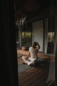 a man sitting on the porch of a house at Mémé Villa Siargao in General Luna +21 photos