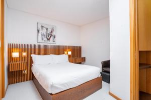 a bedroom with a bed with a wooden headboard at Smartr Porto Reis de Gaia & Spa in Vila Nova de Gaia