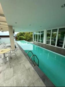 uma piscina num edifício com mesa e cadeiras em relex banglo em Semenyih