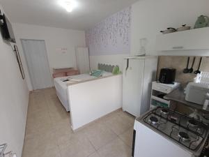 a small kitchen with a stove and white cabinets at Apartamento Privativo com Vaga in São Bernardo do Campo +5 photos