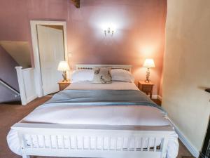 een slaapkamer met een groot wit bed met twee lampen bij Ewe Cottage in Masham