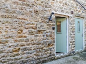 a stone building with a sign that reads give coffee at Ewe Cottage in Ripon