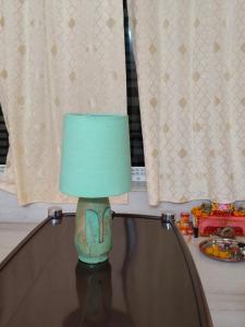 a green lamp sitting on top of a table at Neon Ventures Comfort Stay in Kolkata