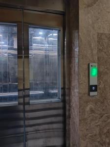 an elevator door with a green light on it at Neon Ventures Comfort Stay in Kolkata