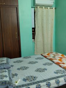 a bedroom with a bed and a curtain at Neon Ventures Comfort Stay in Kolkata