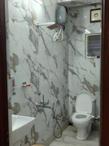 a bathroom with a toilet and a sink at Neon Ventures Comfort Stay in Kolkata