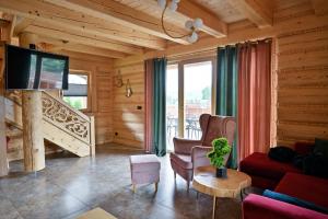 a living room with a couch and a tv at Beskid Wood Houses in Jasnowice