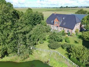 an aerial view of a large house with a pond at Ferienwohnungen Sterdebüll-Hof in Bordelum