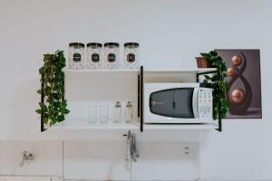a kitchen with a microwave and some glasses on shelves at Stúdio Acolhedor Próximo ao Aeroporto VIX in Vitória
