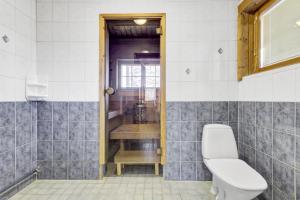 a bathroom with a toilet and a window at Villa Mörhön Maja - Valkea Homes in Pelkosenniemi
