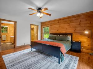 a bedroom with a bed and a ceiling fan at Hot Tub - Cabin Retreat -Firepit - Lake Lure - Chimney Rock in Union Mills +11 photos