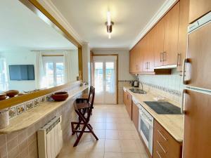 una gran cocina con armarios de madera y una silla. en The Cliffs - Passion Eccehomo, en Viveiro 28 fotos más