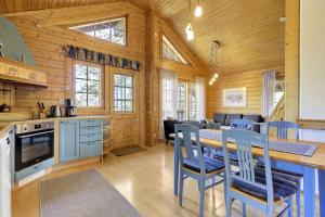 a kitchen and dining room with a table and chairs at Villa Mörhön Maja - Valkea Homes in Pelkosenniemi +36 photos