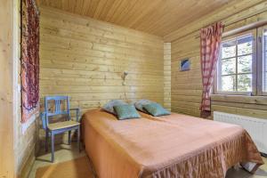 a bedroom with a bed and a blue chair at Villa Mörhön Maja - Valkea Homes in Pelkosenniemi