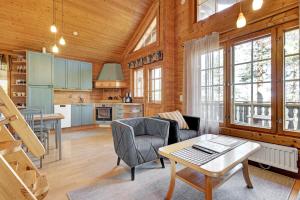 a kitchen and living room with a table and chairs at Villa Mörhön Maja - Valkea Homes in Pelkosenniemi