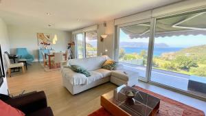Una sala de estar con un sofá blanco y una ventana grande. en The Cliffs - Celtigos Blue Marine, en Porto de Espasante