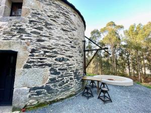 a bath tub sitting next to a stone wall at The Cliffs - The Painted Mill in O Barqueiro