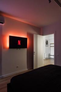 a bedroom with a n sign on the wall at 1,5 BR- Balcony, Netflix, Nespresso, AC, Walk-to-Mall - GrandStay md in Sectorul Botanica