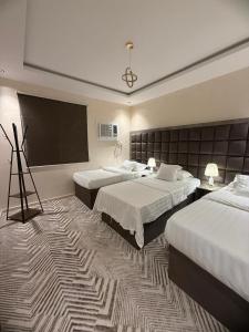 a hotel room with two beds and a projection screen at شقق رومكس Rumex apartments in Al-Salam