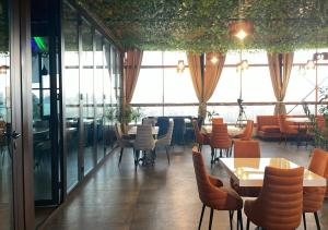 a restaurant with tables and chairs and large windows at Tomu's Hotel in Gyumri
