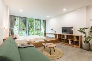 ハノイにあるThe Ivory Dragon Hanoi-Modern Stay with Private Balcony-Free Laundryのソファとテレビのあるリビングルーム
