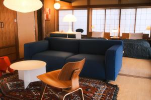 熊本HANAZONO SEVEN的客厅里有一张蓝色沙发和一张床