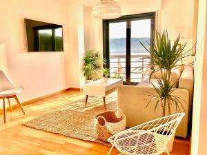 a living room with potted plants and a couch at The Cliffs - Sunset Village Beach 3C in Viveiro