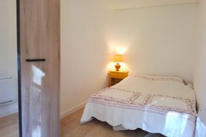 - une petite chambre avec un lit et une lampe dans l'établissement Bright central apartment, à Fréjus