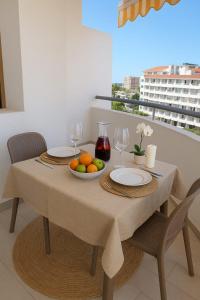 a table with a bowl of fruit and wine glasses at summerland beach in Los Cristianos