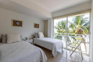 Un dormitorio con dos camas y una gran ventana. en Beachfront 4beds Jacuzzi Privacy Full Kitchen, en La Puntica de Juan Dolio 24 fotos más