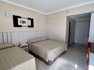 una camera d'albergo con due letti e una tv di Spazzio diRoma a Caldas Novas