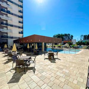 un patio con tavoli e sedie accanto a un edificio di Spazzio diRoma a Caldas Novas