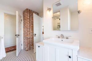 a bathroom with a white sink and a brick wall at Beautifully Restored Home In Manchester Village in Manchester +20 photos
