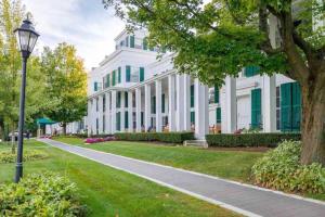 a white building with green windows and a street light at Beautifully Restored Home In Manchester Village in Manchester