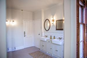 ein weißes Badezimmer mit zwei Waschbecken und einem Spiegel in der Unterkunft Huge 6 Bedroom House in Central Derby in Derby + 72 Fotos