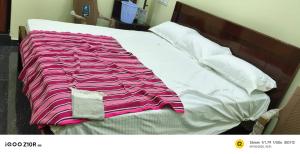 a bed with a pink and white blanket on it at S M LODGe in Dharmapuri