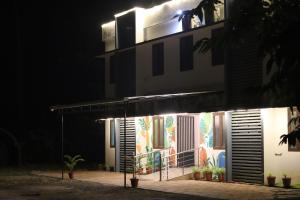 a building with a painting on the side of it at night at bohom STAYORA in Nedumbassery