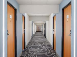 a corridor of a hospital with a carpeted hallway at Novotel Szeged in Szeged