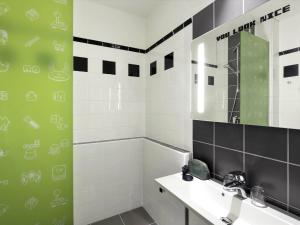 a bathroom with a sink and a mirror at Ibis Styles Budapest Center in Budapest +87 photos