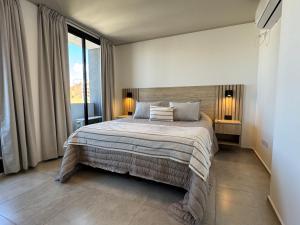 a bedroom with a large bed with two lamps at Rent a Flat Nueva Cordoba in Cordoba +31 photos