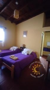 a hotel room with two beds with purple sheets at La Casa de la Abuela Tilcara in Tilcara