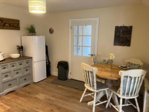 a kitchen with a table and chairs and a refrigerator at Struan Cottage in Ballater