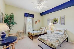 una camera da letto con due letti, un tavolo e una finestra di Coastal condo with pool, lanai, washer/dryer, & elevator a Saint Augustine Beach